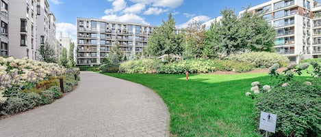 A residential building with a paved pathway and a well-maintained garden.