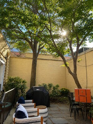 A backyard with a barbecue grill, outdoor furniture, and a tree providing shade. - Spacious 3BR Home in Heart of Montclair – Walkable, Near NYC & Newark Airport (Montclair)