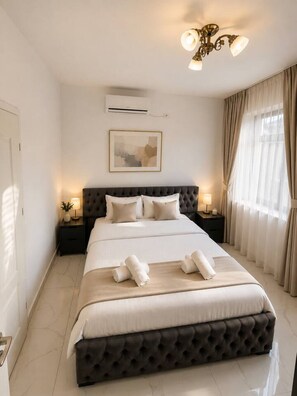 A bedroom with a large bed, a dark headboard, bedside lamps, a ceiling light fixture, and a window with curtains. - Modern Luxury Apartment • Heart of the City (Bucharest)