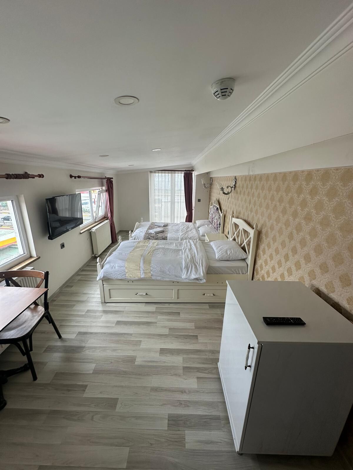 Una habitación de hotel con cama, escritorio, televisor y armario.