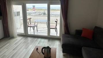 Habitación Confort, balcón, vistas al mar | Zona de estar | Smart TV de 80 cm con canales por satélite