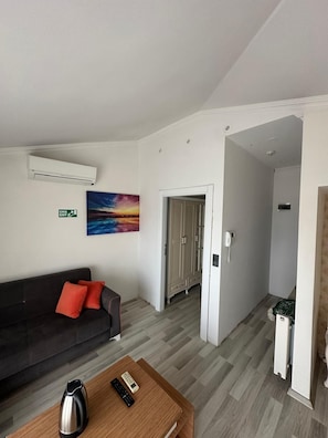 Habitación Confort, balcón, vistas al mar | Zona de estar | Smart TV de 80 cm con canales por satélite