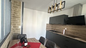 Ein moderner Essbereich mit einem Holztisch, schwarzen Stühlen und einer roten Tischmatte.