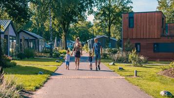 Um bairro residencial com casas modernas, um caminho pavimentado e áreas verdes.