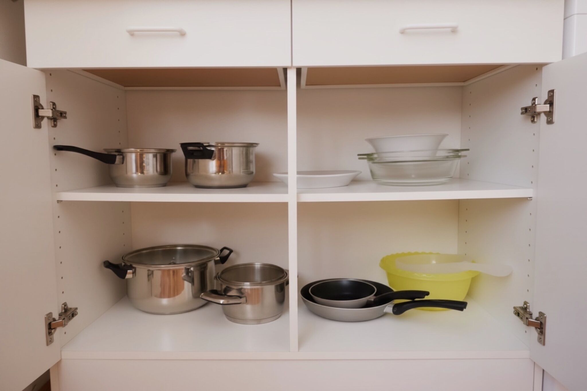 Un meuble de cuisine doté de quatre étagères, chacune contenant divers ustensiles et accessoires de cuisine.