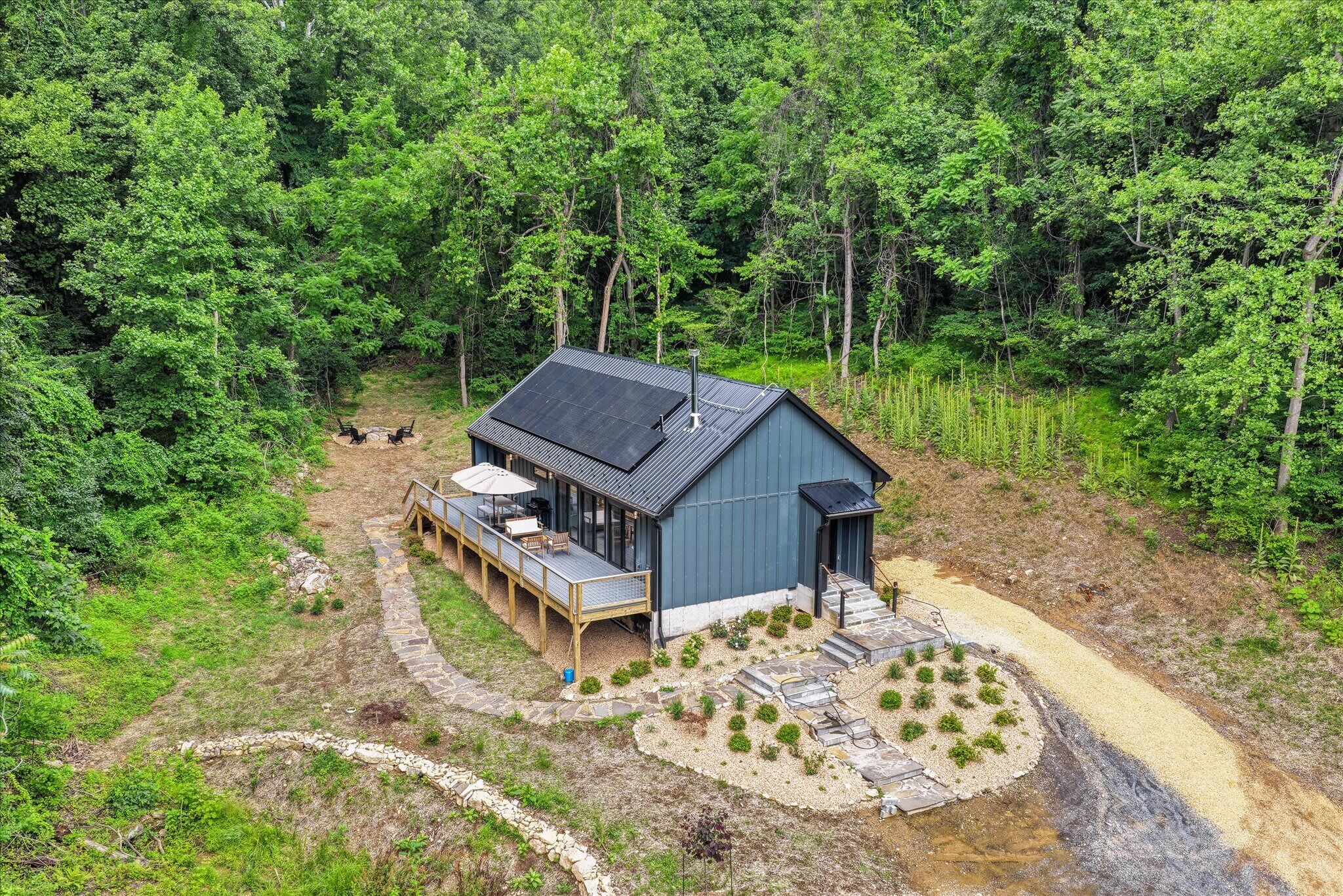A cabin with a deck, a patio, and a small garden area.