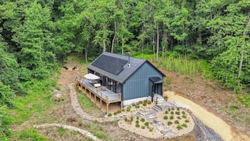 A cabin with a deck, a patio, and a small garden area.
