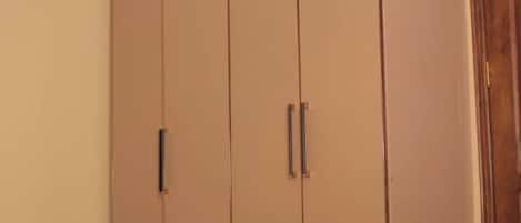 A bedroom with a bed, a wardrobe, and a wooden door.