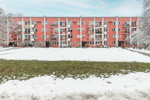 Un immeuble résidentiel rouge à plusieurs étages, doté de balcons et de fenêtres.