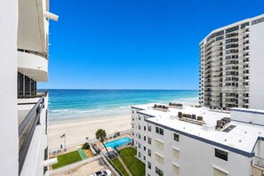A high-rise hotel with a rooftop pool, beach view, and multiple balconies. - Ocean/River View | Heated Pool | Royal Atlantic 8D (Daytona Beach)