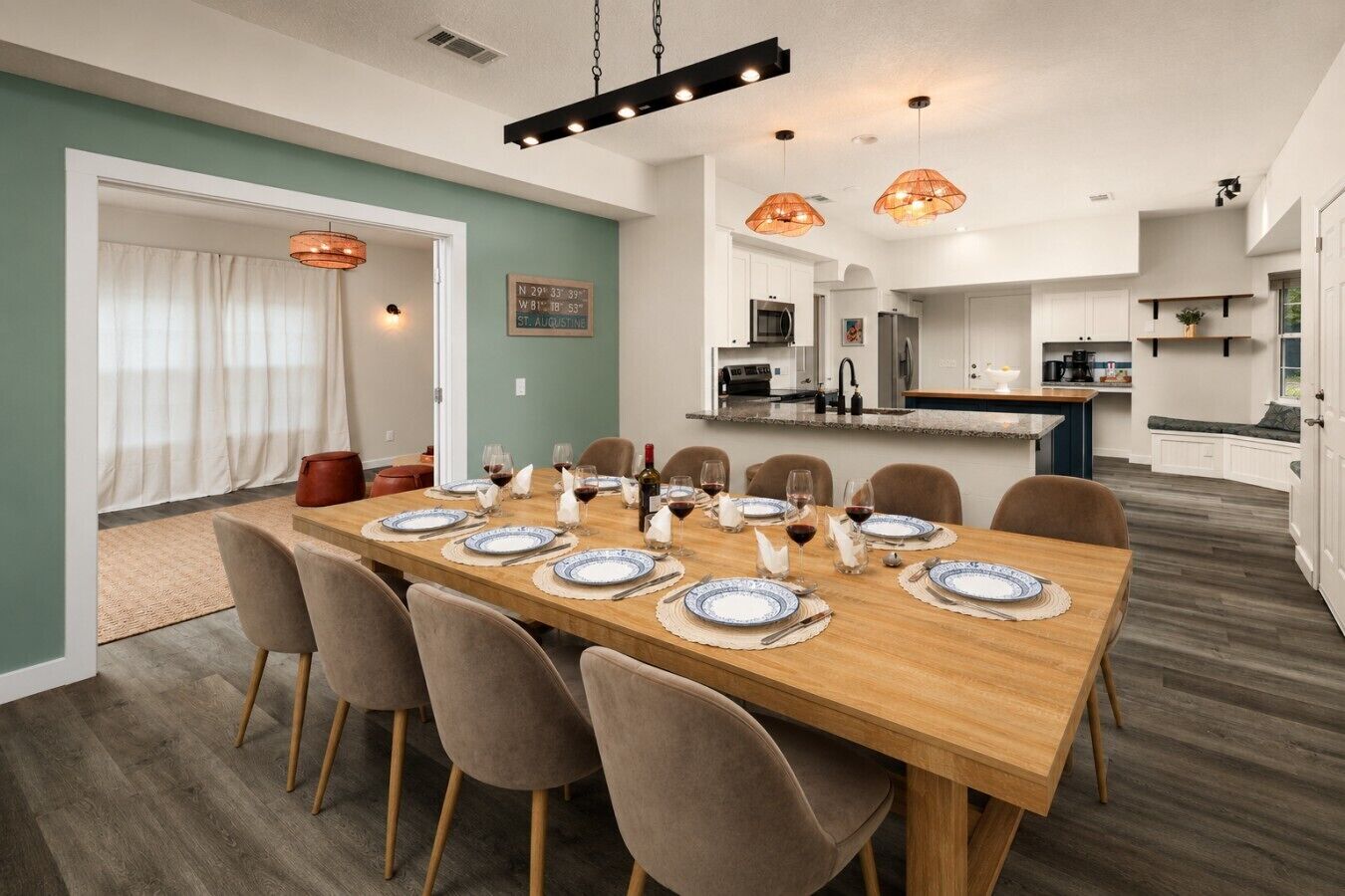 A dining area with a long wooden table set for six, surrounded by six chairs.