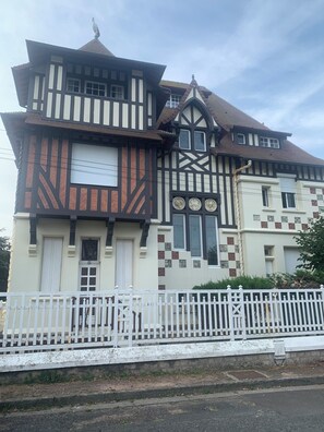 A traditional half-timbered building with a white fence in front.