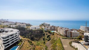 A coastal residential area with modern buildings, a swimming pool, and a view of the sea. - The Garden Escape 2bedroom garden unit (Fuengirola)