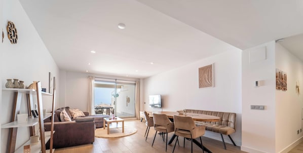 A spacious living area with a sofa, a dining table, and chairs. - Casa Lara — Andalusian Village Retreat (Benalmádena)