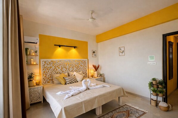Un dormitorio con cama, mesitas de noche, ventilador de techo y estante en la pared con objetos decorativos.