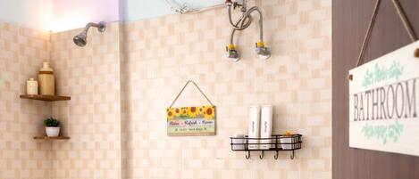 Baño con inodoro, ducha y calentador de pared. Hay un cartel que indica la ubicación del baño.