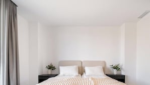 A bedroom with a bed, two bedside tables, and a window with curtains. - Casa Aura Higuerón  -Modern Luxury Apartment with Spectacular valley and sea views- Higueron - Fuengirola (Fuengirola)