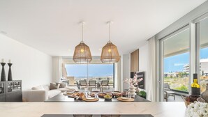 A modern kitchen with a dining area, large windows, and a view of the city. - Casa Aura Higuerón  -Modern Luxury Apartment with Spectacular valley and sea views- Higueron - Fuengirola (Fuengirola)