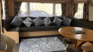 A compact living space with a sofa, a coffee table, and a patterned rug. - 10 Berth Caravan Butlins Skegness Pet Friendly (Skegness)