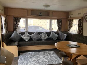 Ein gemütlicher Wohnbereich mit Sofa, Couchtisch und einem gemusterten Teppich.