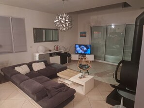 Ein modernes Wohnzimmer mit einer Couch, einem Couchtisch, einem Fernseher und einem Kamin.