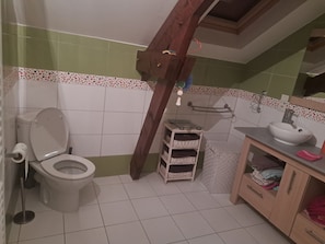 A bathroom with a toilet, a sink, and a mirror. There is a wooden beam structure above the toilet. - 140 m2 fenced house (Pouzac)