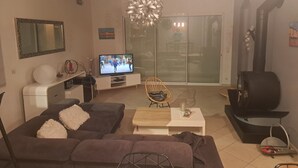 A living room with a sofa, television, and a fireplace. - 140 m2 fenced house (Pouzac)
