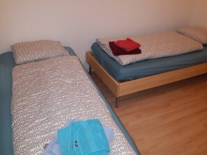 Un dormitorio con dos camas, una con ropa de cama estampada y la otra con ropa de cama de color liso.