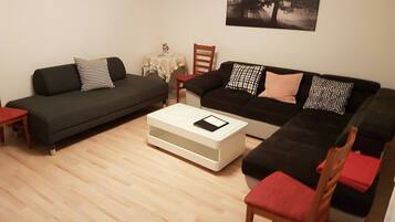 A living room with two sofas, a coffee table, and a chair.