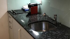 A kitchen with a stainless steel sink, a microwave, and a red appliance on the countertop. - Parkareal Davos Apartment (Davos)
