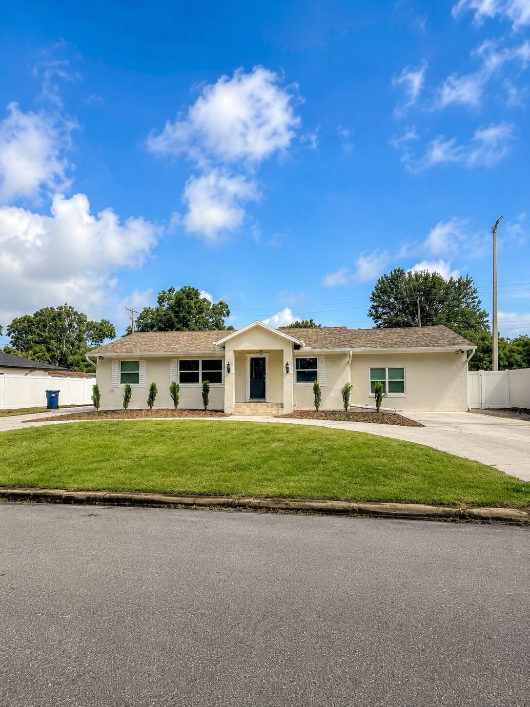 Une maison à deux étages avec un porche à l’avant, un garage et une pelouse bien entretenue.