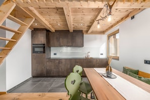 A modern kitchen with dark cabinets, a stainless steel countertop, and a built-in oven.