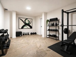 A gym with weightlifting equipment, a bench, and a wall-mounted rack. - Ultra Luxury Villa, Breathtaking Bay views (Dobrota)