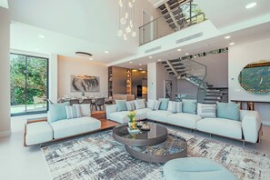 A modern living room with a sectional sofa, a coffee table, and a staircase leading to an upper level. - Ultra Luxury Villa, Breathtaking Bay views (Dobrota)