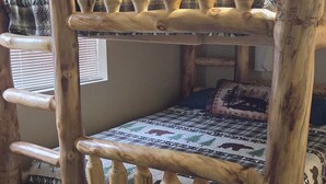 A bunk bed with a wooden frame and a quilt with a forest and animal pattern. - Husky Bear Retreat - Beautiful house in the tall pines of Pinetop Lakeside (Pinetop-Lakeside)