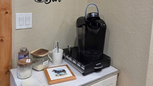 A kitchenette with a coffee machine, a clock, and a wall sign that reads 'Coffee Bar.' - Husky Bear Retreat - Beautiful house in the tall pines of Pinetop Lakeside (Pinetop-Lakeside)