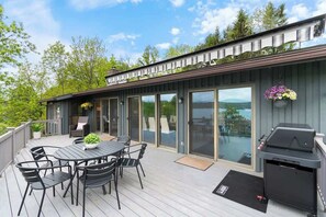 Eine Terrasse mit Tisch, Stühlen, einem Grill und Blick auf die Landschaft.