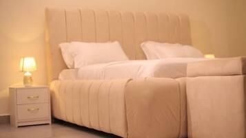 Uma cama com cabeceira, mesa de cabeceira com gavetas e um abajur.