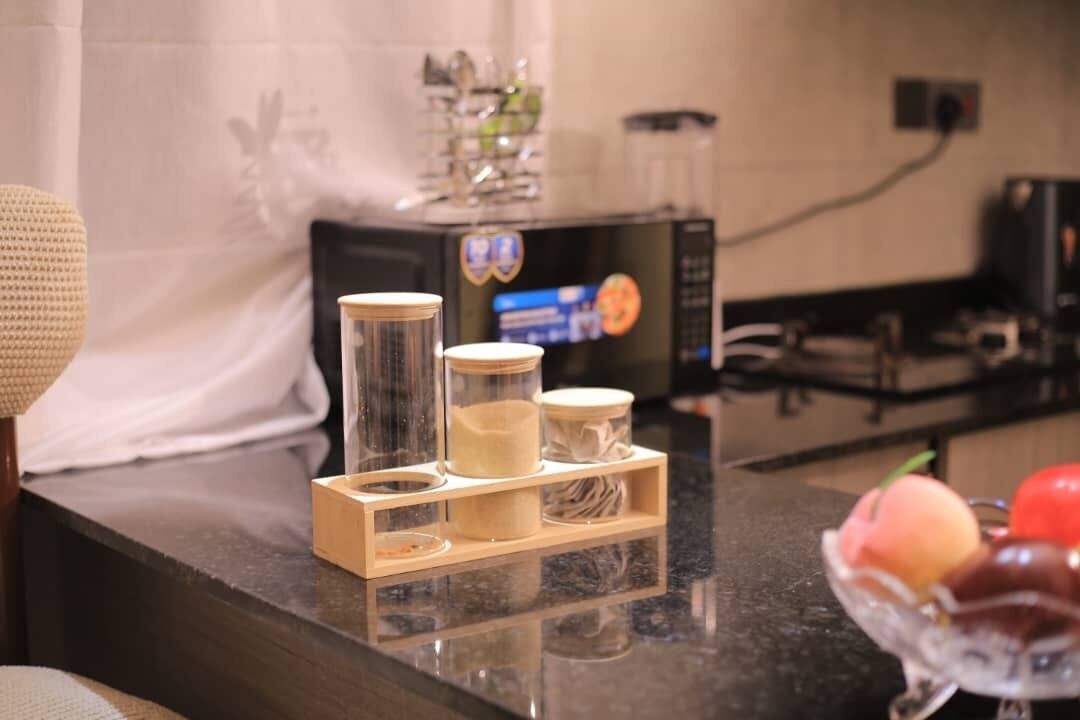 Een aanrecht met een koffiezetapparaat, een magnetron en een schaal met fruit.
