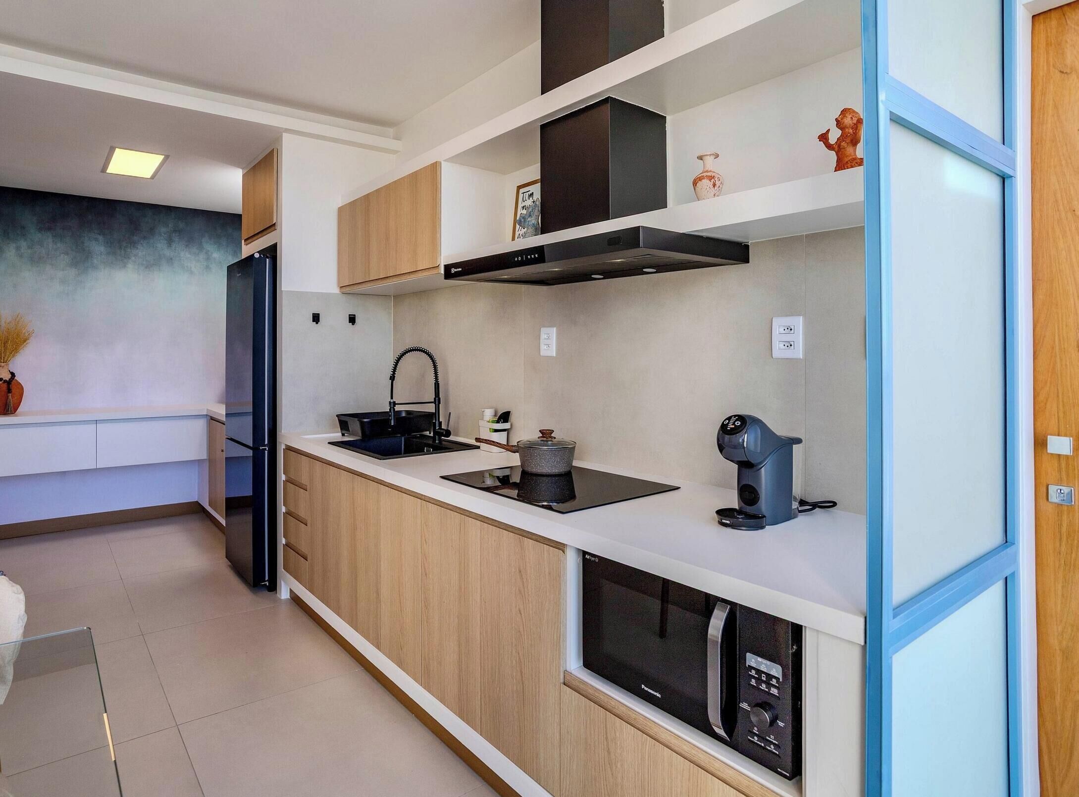 A modern kitchen with a built-in oven, a coffee machine, and a microwave.