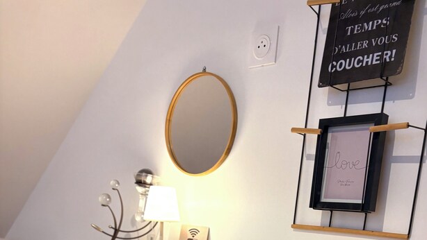 A small, modern kitchenette with a wooden countertop, a stool, a mirror, and a wall-mounted shelf with a sign. - Le Mocopek Vacation Rental (sleeps 5) (Bolbec)
