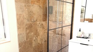 A bathroom with a glass-enclosed shower, a white sink, and a mirror. - Le Mocopek Vacation Rental (sleeps 5) (Bolbec)