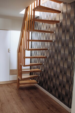 Una escala de fusta amb un mur amb disseny geomètric.