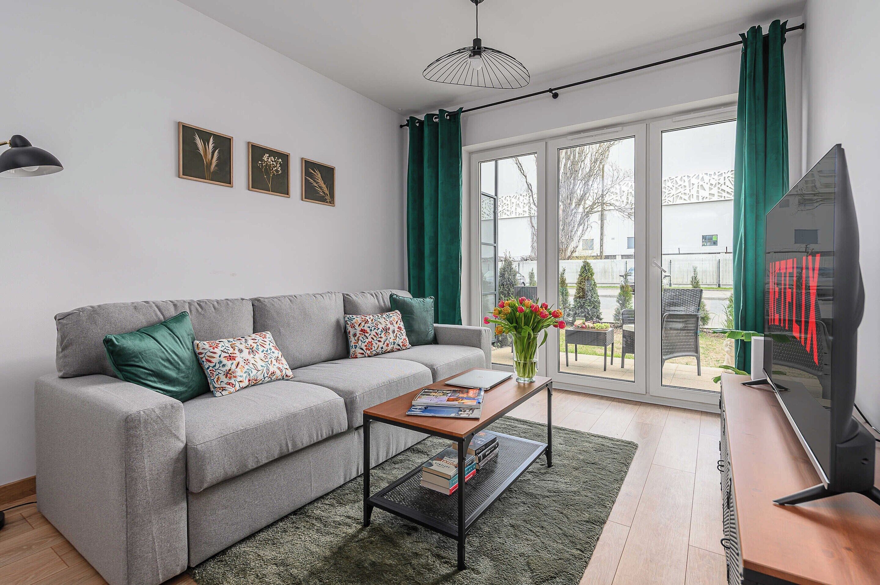 A modern living room with a grey sofa, a coffee table, and a television.