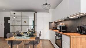 A modern kitchen with a wooden countertop, built-in oven, and a coffee machine.