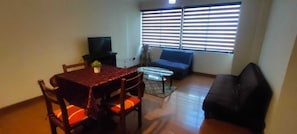 A dining area with a table, chairs, a sofa, and a television. - Spacious, comfortable 2-bedroom apartment, Sopocachi - La Paz, Bolivia (La Paz)