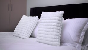 A bed with white bedding and two pillows.