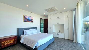 A modern bedroom with a bed, wardrobe, and a painting on the wall.