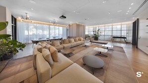 Un salón amplio con un sofá modular grande, una mesa de centro y un comedor con mesa y sillas.