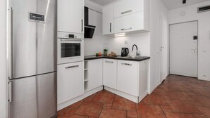 Une cuisine moderne avec des meubles blancs, un réfrigérateur en acier inoxydable, un four et un four à micro-ondes de la marque Bosch.